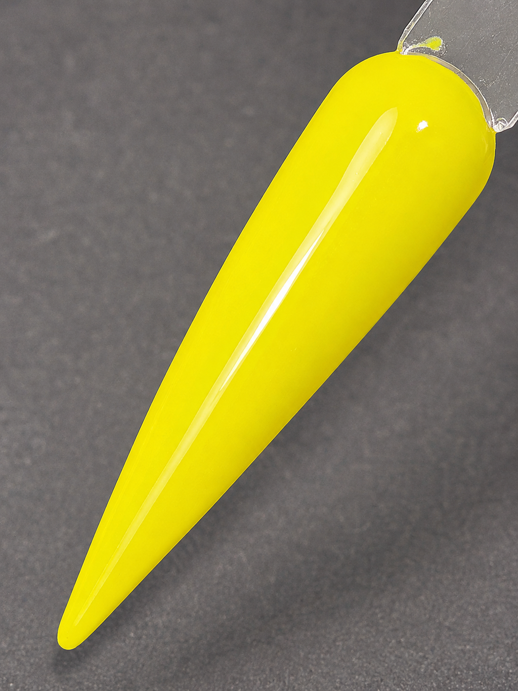A bright neon yellow nail polish cone on a dark gray textured background.