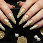 Gold holographic glitter nails with white oval flakes on black velvet