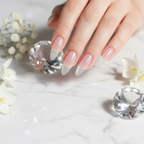 Sheer glass-like clear nails on white marble with crystal prism and white flowers